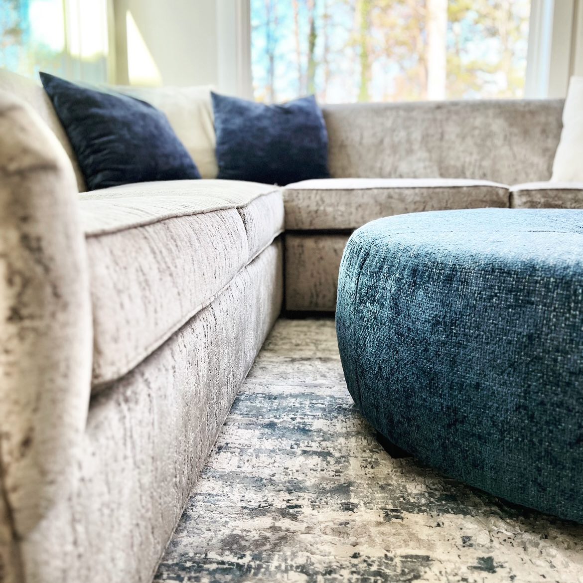 Photo featuring custom fabric and upholstery for a grey sofa and blue ottoman 
