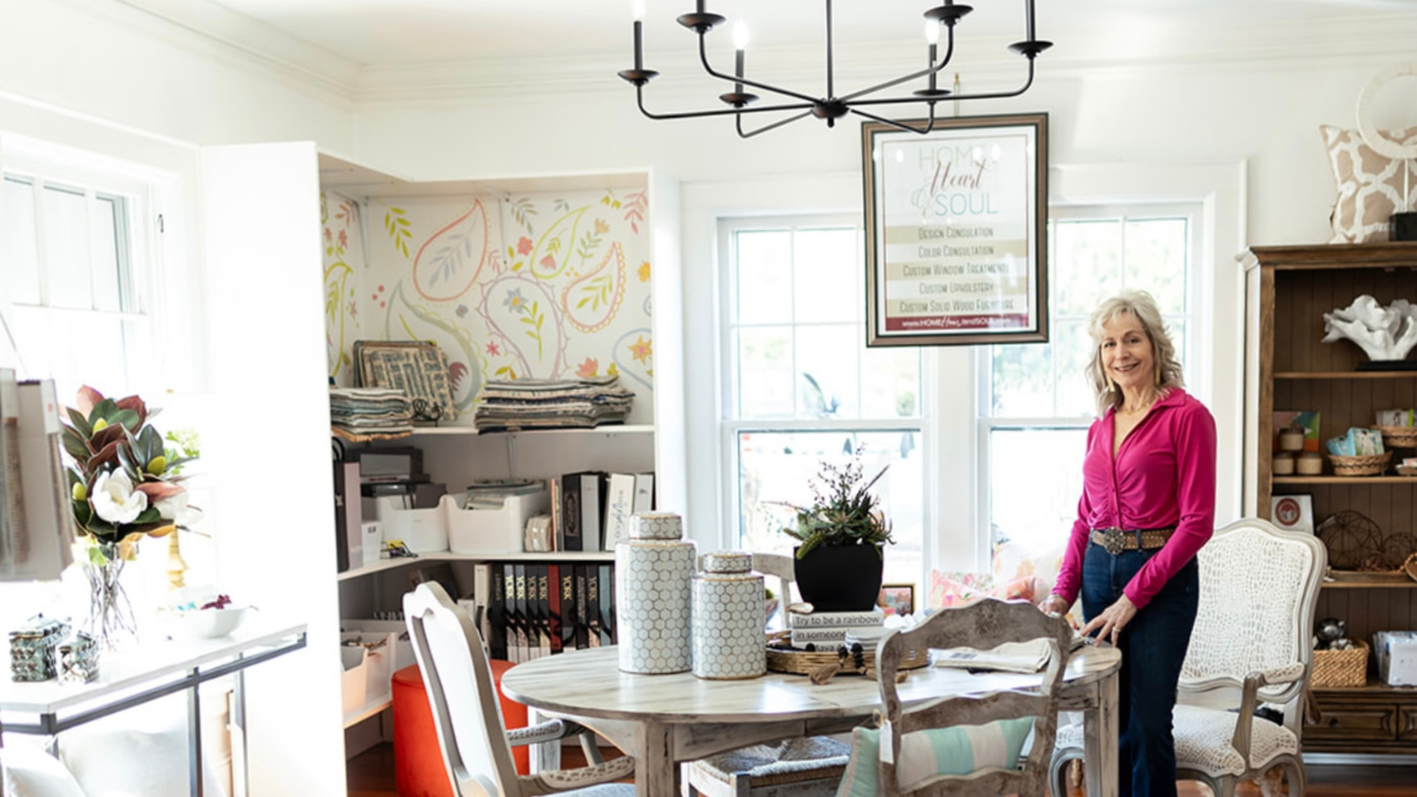 Photo of Lori Savio standing next to a table inside her Home, Heart & Soul design center boutidue