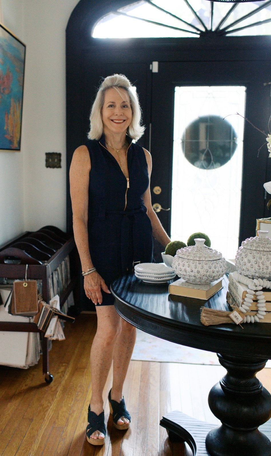 Lori Savio standing in the foyer of Home, Heart & Soul room with a table displaying decorative items