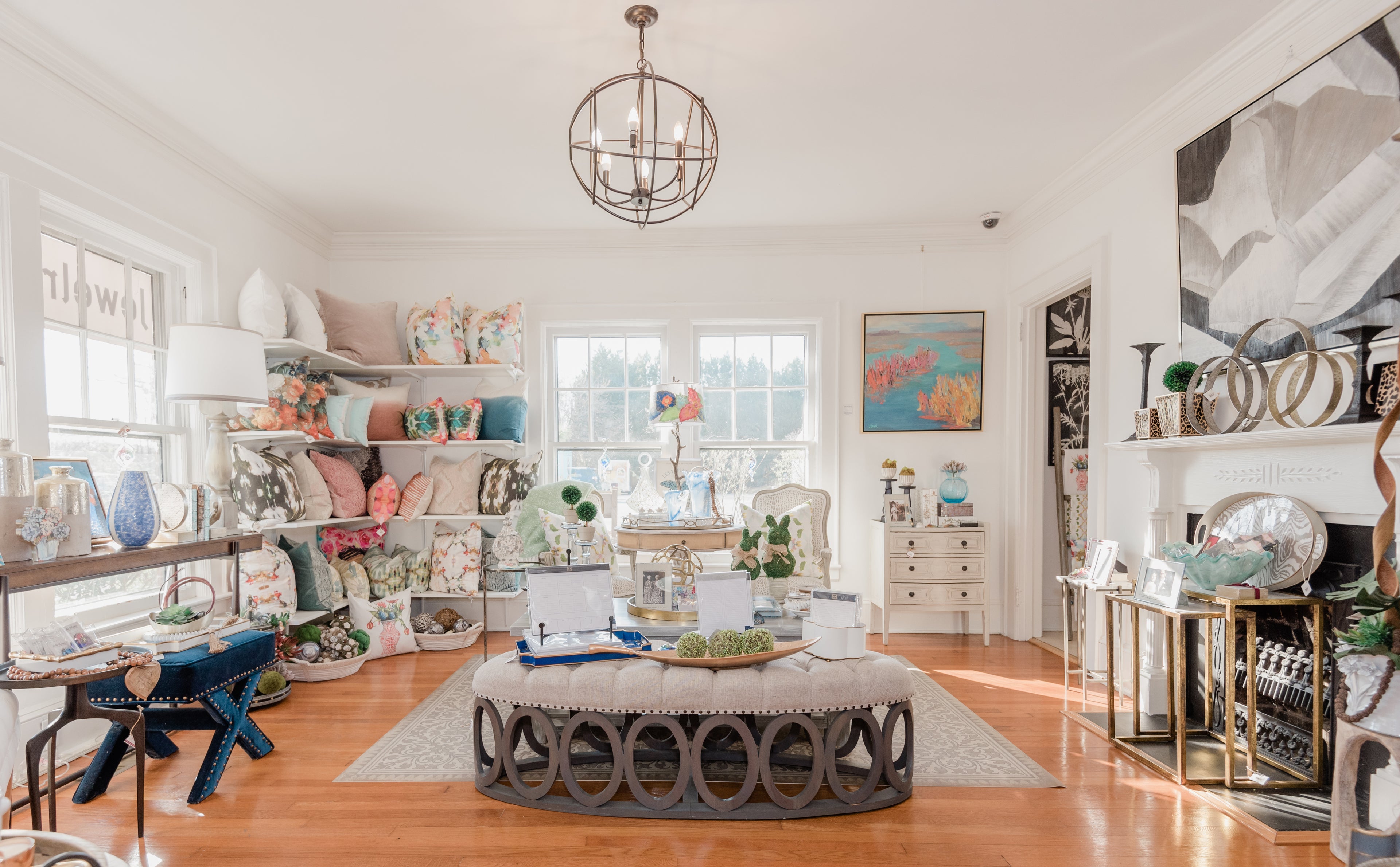 Photo of the inside of Home, Hear & Soul, a home décor and gift shop located in Cornelius, North Carolina. The photo features artwork, pillows, and home accessories