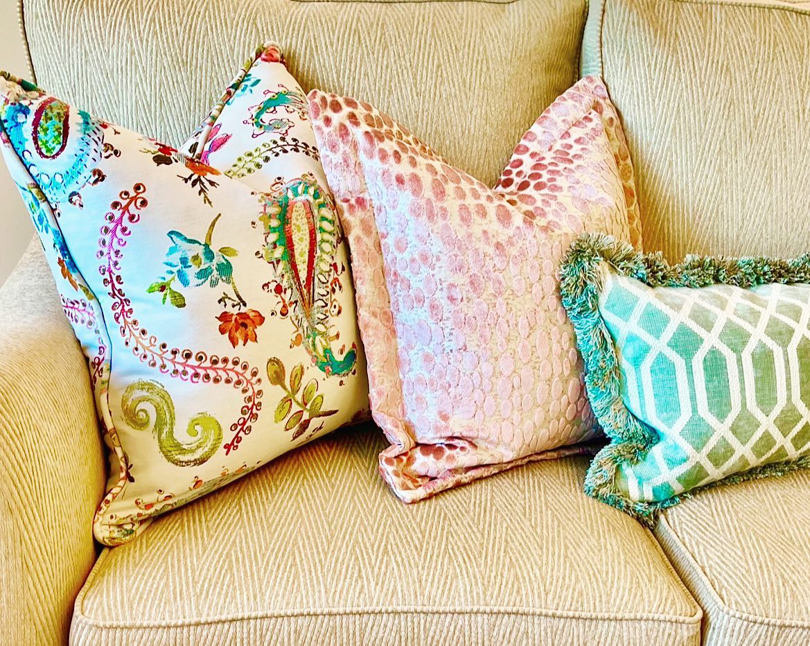 Three pillows on a beige couch