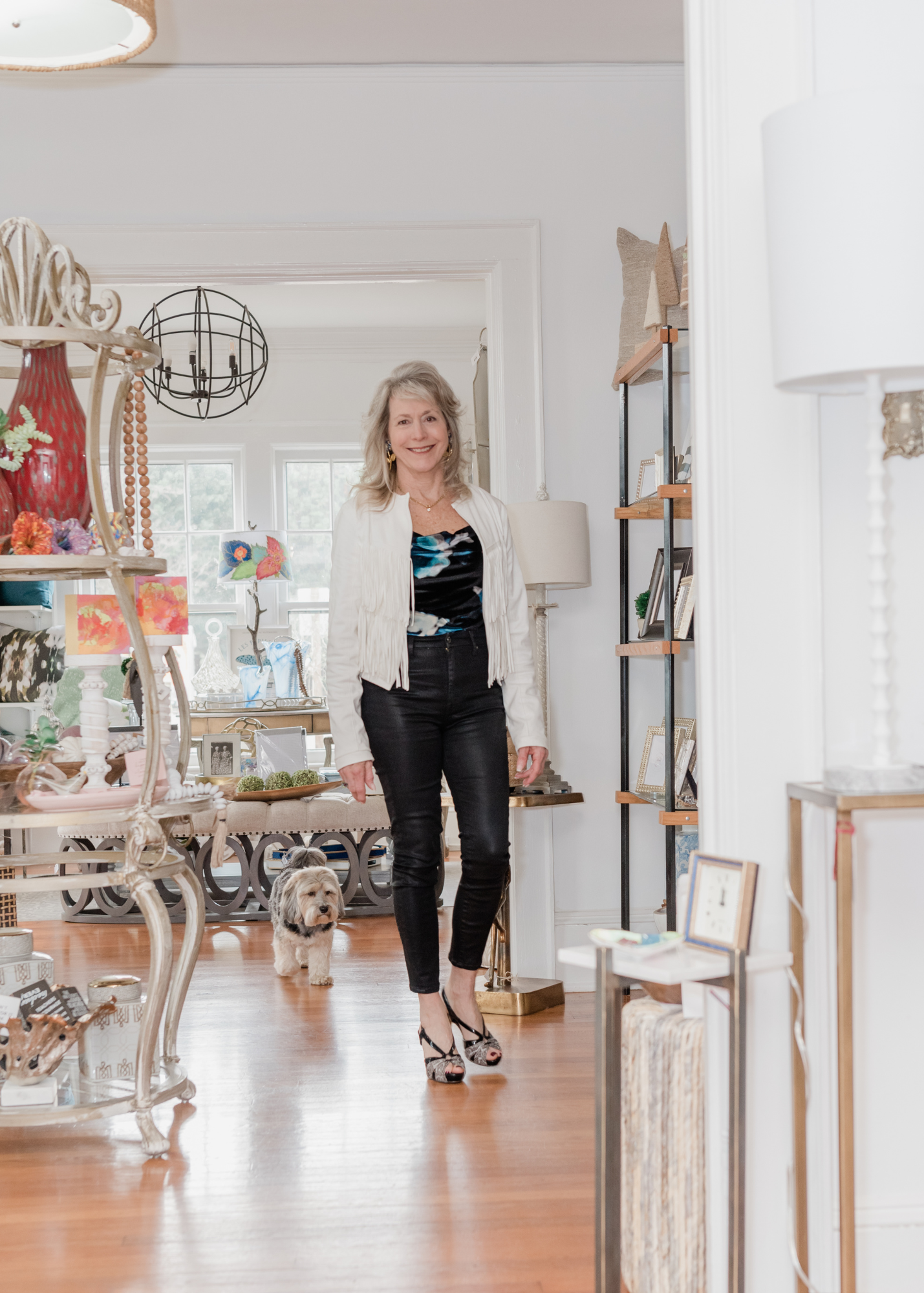 Lori Savio, Owner of Home, Heart & Soul, standing inside her shop with her dog, Enzo